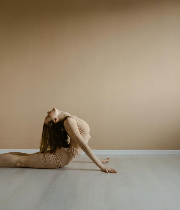 A woman in a stretching pose, conveying flexibility and body awareness.